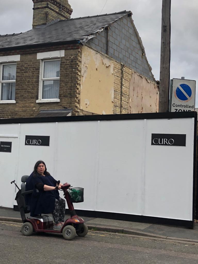 Councillor Naomi Bennett in front of a gap between houses left by a recently demolished building