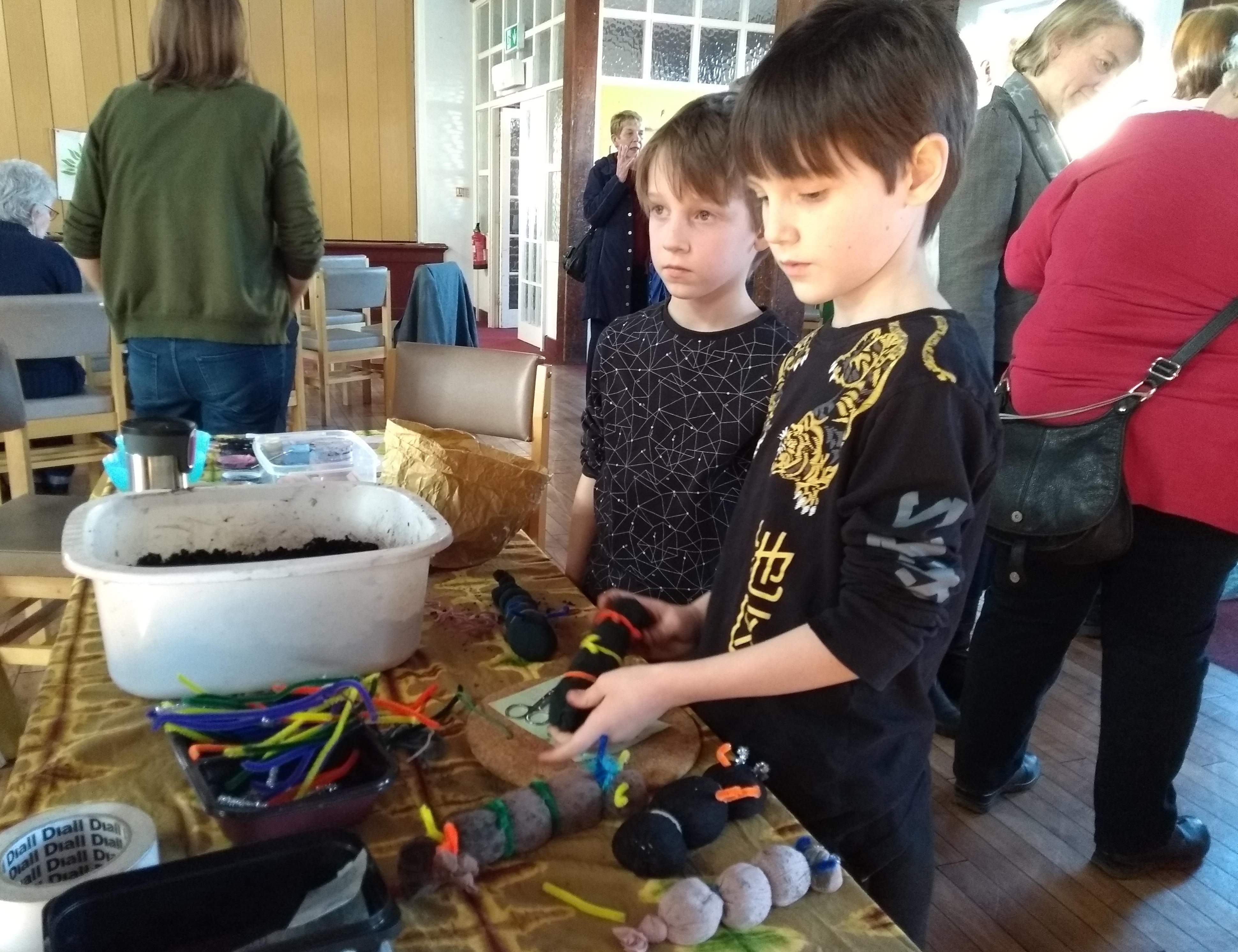 Kids getting their hands dirty assembling their grass caterpillars