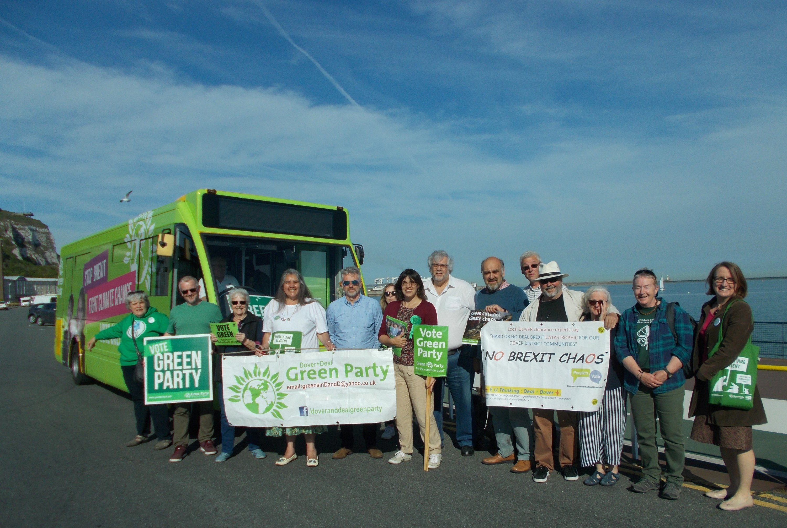 Local Greens stand with banners outside the electric campaign bus on Dover seafront